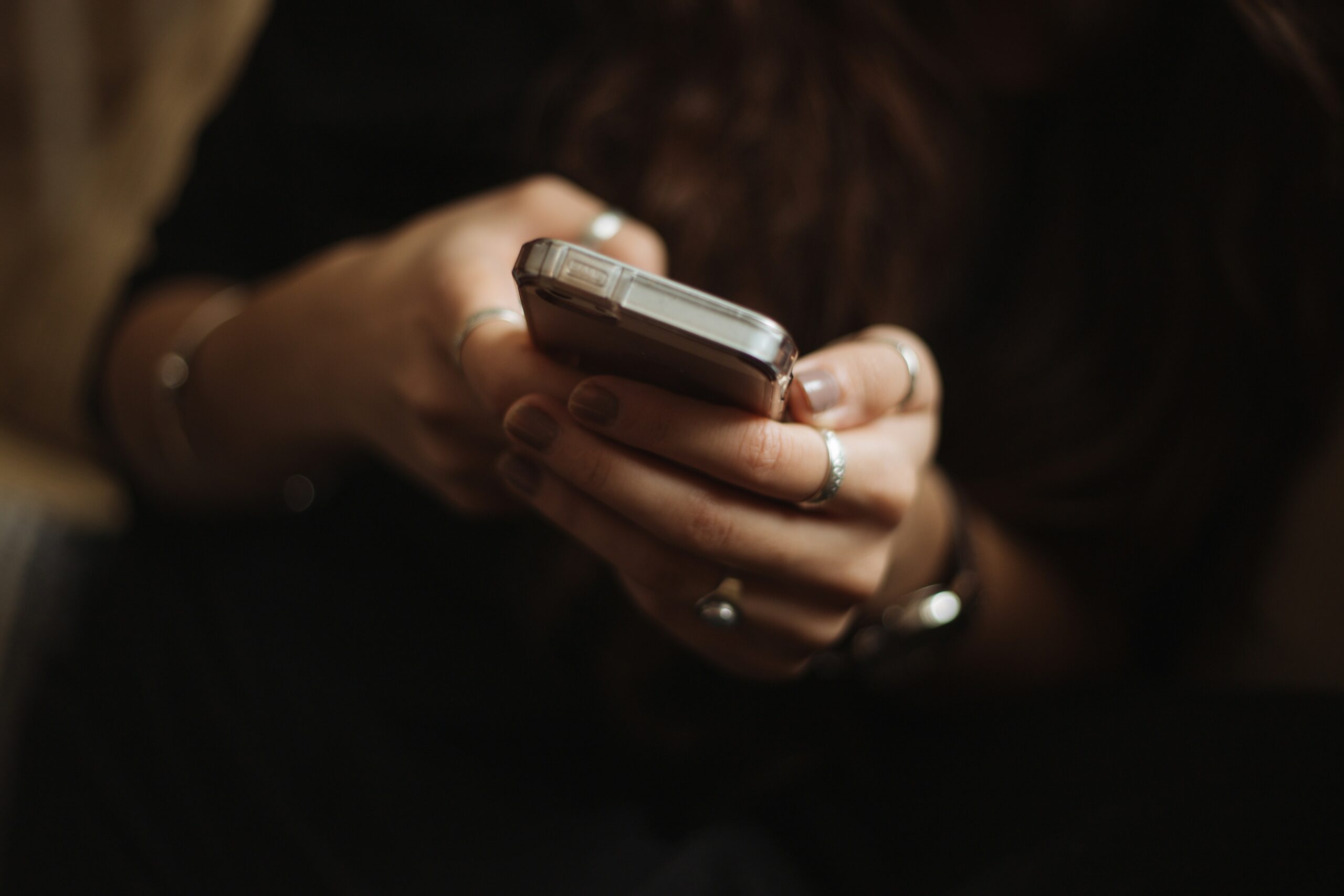 Close-up of a hand holding a smartphone in a dim room
