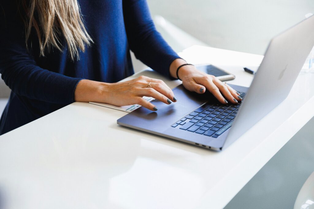 Close-up of hands typing on a laptop keyboard