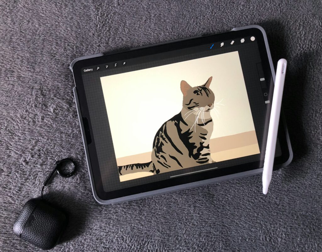 Person using a stylus to draw a cat illustration on a tablet