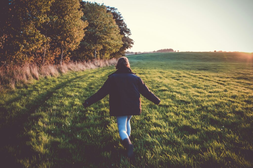 Person walking outdoors taking a deep, calming breath