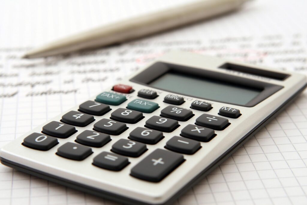 calculator and pen on top of documents