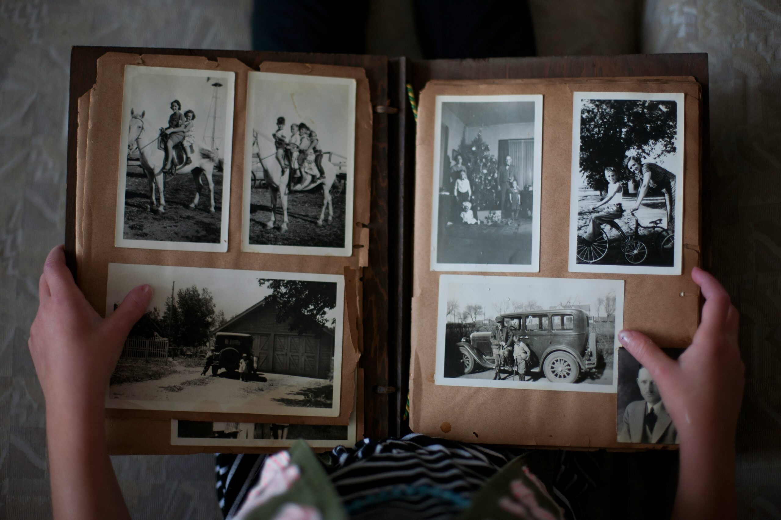 Hands holding an open photo album filled with old family photos