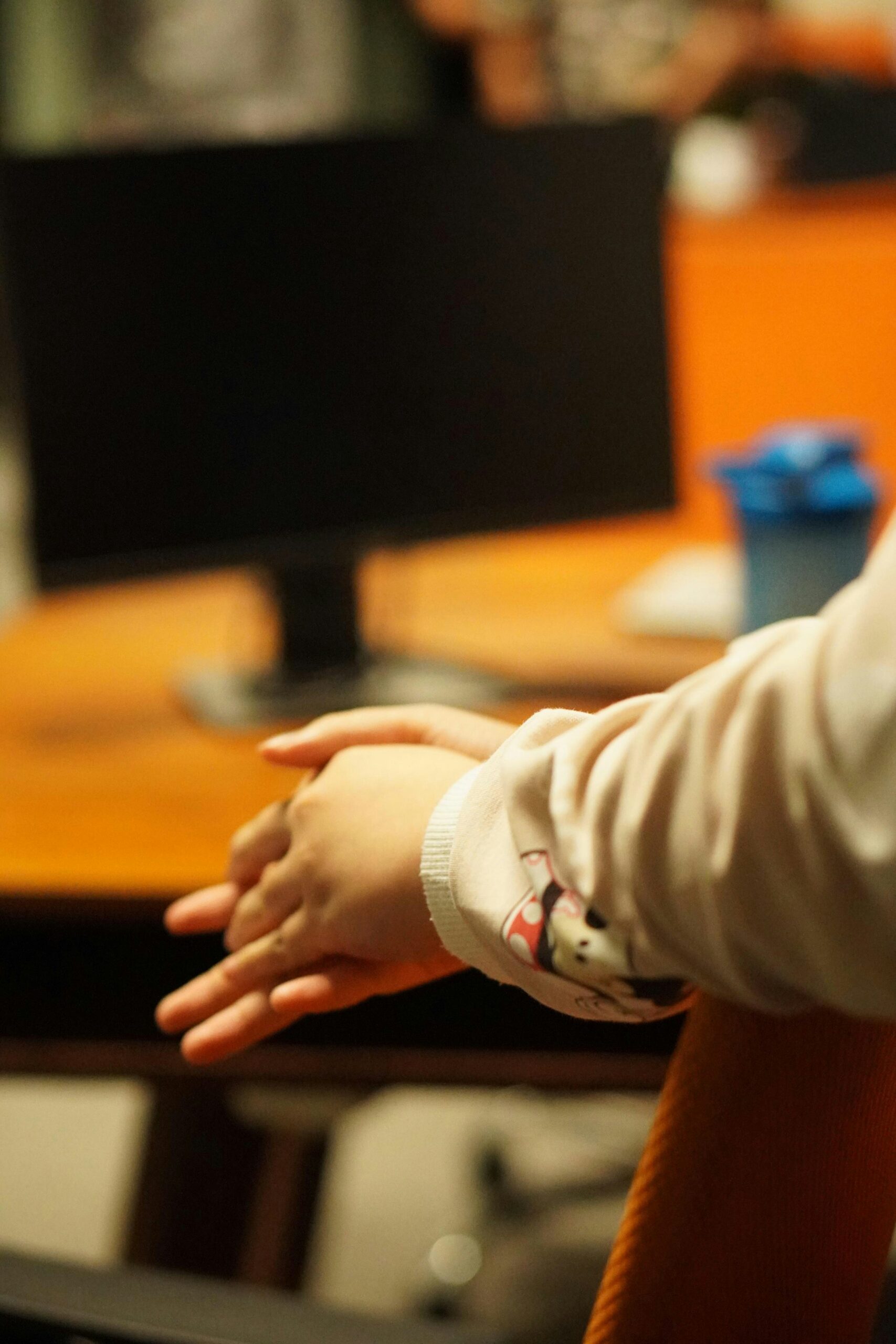Hands resting calmly on a desk